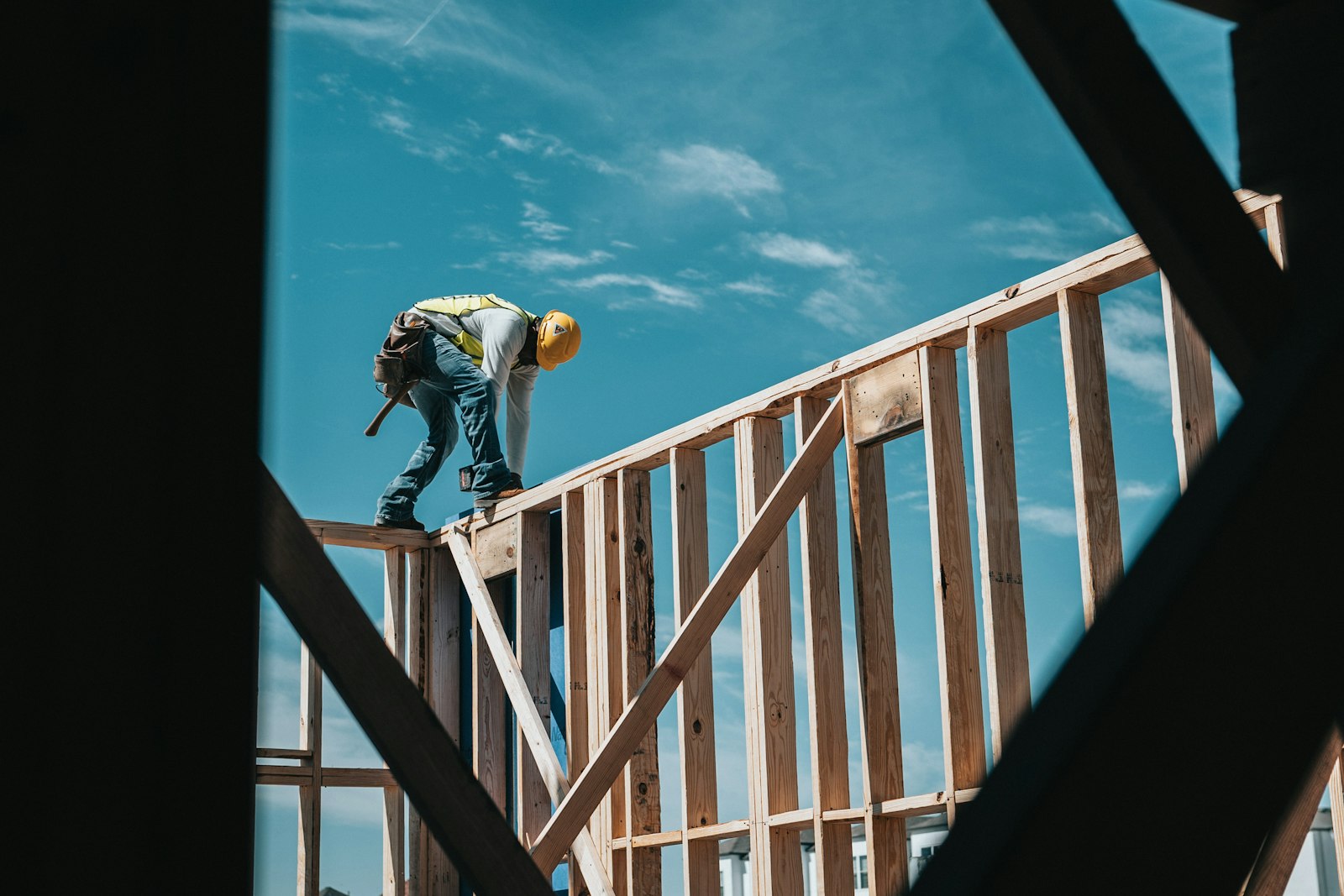 Builder standing on the timber frame of a new home