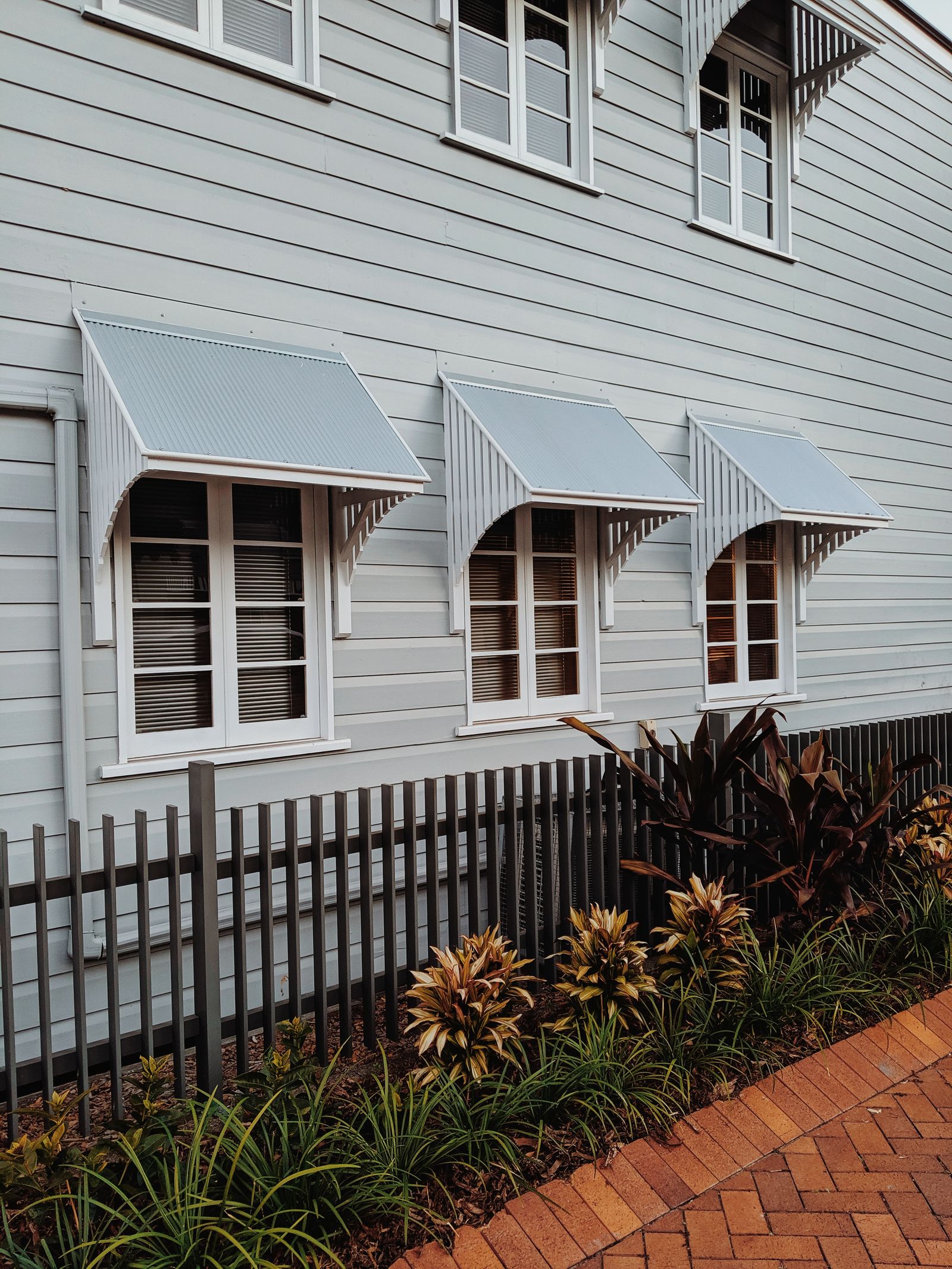 Queenslander weatherboard home in Brisbane with window awnings